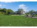 Expansive backyard with screened pool, fire pit, and lush green lawn perfect for entertaining and relaxation at 1606 Wildcat Ct, Winter Springs, FL 32708