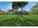Lush green backyard featuring a screened-in pool enclosure, mature trees, and plenty of space for outdoor activities at 1606 Wildcat Ct, Winter Springs, FL 32708