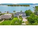 Aerial view of a luxurious waterfront home with lush landscaping and expansive water views at 2504 Gatlin Ave, Orlando, FL 32806