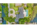 An aerial view of an estate home, manicured grounds and a pool, overlooking the pristine lake at 2504 Gatlin Ave, Orlando, FL 32806