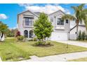 Charming two-story home featuring a well-manicured lawn and mature trees at 2831 Orange Haven Way, Kissimmee, FL 34746