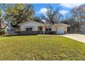 Charming single-story home with a well-manicured lawn, brick accents, and an attached one car garage at 2833 Ne 18Th Ct, Ocala, FL 34470