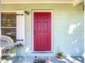 Close up of the bright red front door featuring stylish white shutters and matching decor at 32804 Blossom Ln, Leesburg, FL 34788