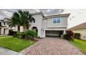 Lovely home exterior with an open garage and paved driveway, surrounded by lush greenery at 3854 Carrick Bend Dr, Kissimmee, FL 34746