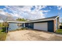 A single-story home has light blue siding with a brick accent and large driveway at 38934 Sulen Rd, Lady Lake, FL 32159