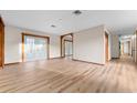 Large living space boasts light wood floors, wood trim, and natural light from French doors at 38934 Sulen Rd, Lady Lake, FL 32159