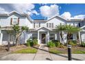 Light blue townhouse featuring manicured landscaping, a covered entryway, and brown shutters at 5354 Diplomat Ct # 106, Kissimmee, FL 34746