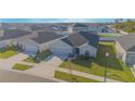 A single-story house featuring a well-manicured lawn, gray exterior paint, and attached garage at 5430 Pine Lilly Dr, St Cloud, FL 34771