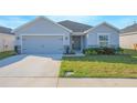 Single-story home featuring a well-manicured lawn, gray exterior paint, and attached garage at 5430 Pine Lilly Dr, St Cloud, FL 34771