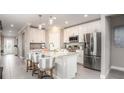 Bright kitchen featuring white cabinets, stainless appliances, granite countertops and an island with stools at 5563 Maddie Dr, Haines City, FL 33844