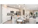 Bright kitchen featuring white cabinets, stainless appliances, granite countertops and an island with stools at 5563 Maddie Dr, Haines City, FL 33844
