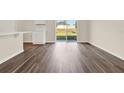 Bright living room featuring wood-look flooring and sliding glass doors to the backyard at 5844 Galloping Dr, Apopka, FL 32712