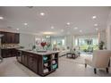 Open concept living space featuring a kitchen island, dining area, and comfortable living room arrangement at 6598 Lullaby Way, Mascotte, FL 34753