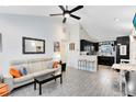 Open-concept living room with modern furniture, a ceiling fan, and an open view into the modern kitchen at 720 N Pennsylvania Ave, Winter Park, FL 32789