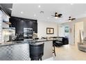 Modern kitchen featuring stainless steel appliances, a black marble backsplash and a stylish breakfast bar at 726 N Pennsylvania Ave, Winter Park, FL 32789