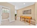 Bright dining room featuring an adjacent bathroom, wooden table and stylish decor at 7663 Recife Dr, Kissimmee, FL 34747