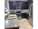 Modern kitchen featuring dark wood cabinets, granite countertops, stainless steel appliances, and tiled flooring at 1107 Galway Blvd, Apopka, FL 32703