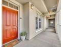 Well-lit hallway with an orange entrance door, neutral walls, and an exit sign at 1211 Stonecutter Dr # 304, Celebration, FL 34747