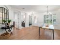 Bright dining room featuring wood floors, large windows, modern chandelier, and neutral decor at 1230 Mercedes Pl, Orlando, FL 32804