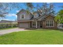 Charming two-story home with stone accents, attached two car garage, and expansive manicured lawn at 1230 Mercedes Pl, Orlando, FL 32804