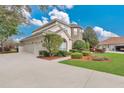 Spacious home featuring a large driveway leading to a three-car garage and beautifully landscaped front yard at 1601 Billingshurst Ct, Orlando, FL 32825