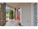 Inviting front porch featuring a red double door entrance, brick columns, and charming flower pot accents at 1601 Billingshurst Ct, Orlando, FL 32825