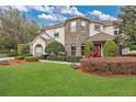 Beautiful two-story home with lush green lawn, well-maintained landscaping, and a welcoming red double-door entrance at 1601 Billingshurst Ct, Orlando, FL 32825