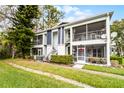 Exterior view of a two-story condo building featuring screened balconies, neat landscaping, and access stairs at 2106 Northlake Dr # 2106, Sanford, FL 32773