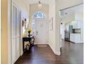 Bright foyer featuring dark hardwood floors, a decorative console table, and a view of the kitchen at 216 Springside Rd, Longwood, FL 32779