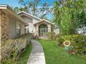 Landscaped front yard with a brick accent, pathway leading to the home's entrance, and decorative yard ornaments at 216 Springside Rd, Longwood, FL 32779