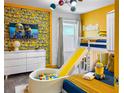 bedroom featuring yellow minion wallpaper, a bunkbed with slide, and ball pit at 2904 Penelope Loop, Kissimmee, FL 34746