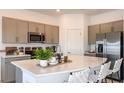 Bright kitchen featuring quartz countertops, gray cabinetry, and modern stainless-steel appliances at 3587 Davenport Creek Ct, Kissimmee, FL 34746