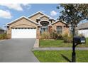 Charming single Gathering home featuring stone accents, a two-car garage and beautiful landscaping at 4057 Sunny Day Way, Kissimmee, FL 34744