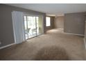 Spacious living room featuring plush carpet and a sliding glass door to a balcony at 4109 Dijon Dr # 4109H, Orlando, FL 32808