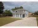 Home exterior with a concrete driveway, manicured lawn, and dark shutters providing contrast against the home's siding at 4191 Sw 110Th Ln, Ocala, FL 34476