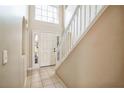 Bright foyer with tile floors, white staircase, and a front door with glass panels allowing natural light to flow in at 4191 Sw 110Th Ln, Ocala, FL 34476