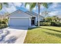 Charming single-story home features a well-manicured lawn and an attached two-car garage at 515 Mickleton Loop, Ocoee, FL 34761