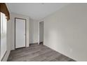 The bright bedroom features gray wood-look flooring, neutral walls, and a white door for a clean aesthetic at 5227 Orange Ave, Port Orange, FL 32127