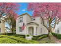 Beautiful two-story home with light stucco, blue shutters and a vibrant pink tree in the front yard at 5238 Baskin St, Orlando, FL 32814