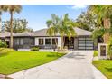 Charming exterior view of a single-story home with modern garage door and landscaped yard at 724 Lake Davis Dr, Orlando, FL 32806