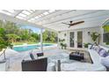 A covered outdoor patio area with furniture, ceiling fan, and a view of the pool at 10236 Chorlton Cir, Orlando, FL 32832