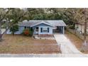 Lovely single-story home with a covered carport, complemented by a well-maintained front yard, and mature trees at 103 Brown Dr, Sanford, FL 32773