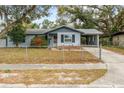 Inviting single-story home with a quaint front yard, covered carport, and mature trees providing shade at 103 Brown Dr, Sanford, FL 32773