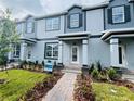 Stylish light blue townhome with dark trim, offering a landscaped front yard and inviting covered entry at 15352 Burgtheater Dr, Winter Garden, FL 34787
