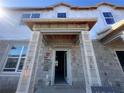 Unfinished new construction home with a covered front entrance, block construction, and window openings at 15352 Burgtheater Dr, Winter Garden, FL 34787
