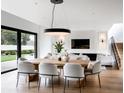 Elegant dining room with a large wooden table, modern chandelier, and an open layout connecting to the living area at 1917 Geigel Ave, Orlando, FL 32806