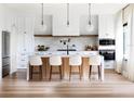 Bright, open kitchen with white cabinets, marble countertops, a large island with seating, and modern stainless steel appliances at 1917 Geigel Ave, Orlando, FL 32806