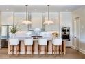 Bright kitchen with a center island, white cabinets, stainless steel appliances, and modern pendant lighting at 2102 S Osceola Ave, Orlando, FL 32806