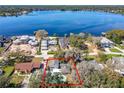 Aerial view of a lakefront property surrounded by lush trees with a private pool, outlined in red at 215 Nob Hill Cir, Longwood, FL 32779
