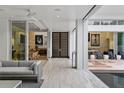 Open-concept living room with access to an outdoor lounge and a view of the pool area and modern tile flooring at 229 Alexander Pl, Winter Park, FL 32789